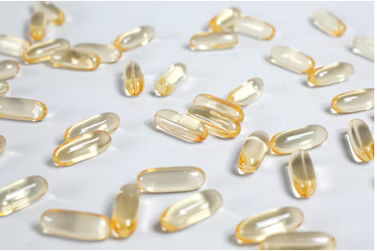 Clear supplement softgels scattered on a white table